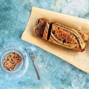 Photo of banana bread with a loose slice on a tray