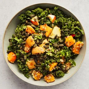 Foto van een schaal met winterse boerenkoolsalade met geroosterde pompoen en appel