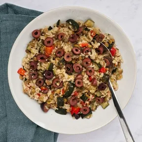 Photo of brown rice with lentils and olives on a plate