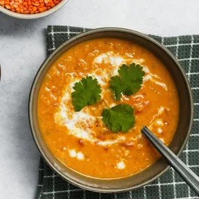 Foto van een kom curry-linzensoep met kokosmelk