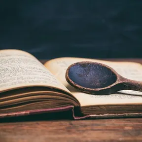 Stockfoto van een oud kookboek met een pollepel