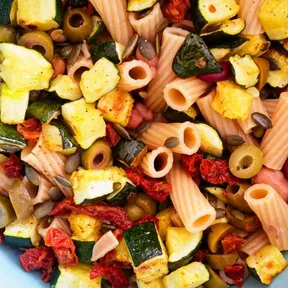 Foto van een kom met simpele vegan pastasalade met gegrilde courgette