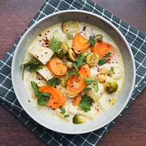 Photo of a bowl of vegetable stew with Brussels sprouts, carrots and parsnips