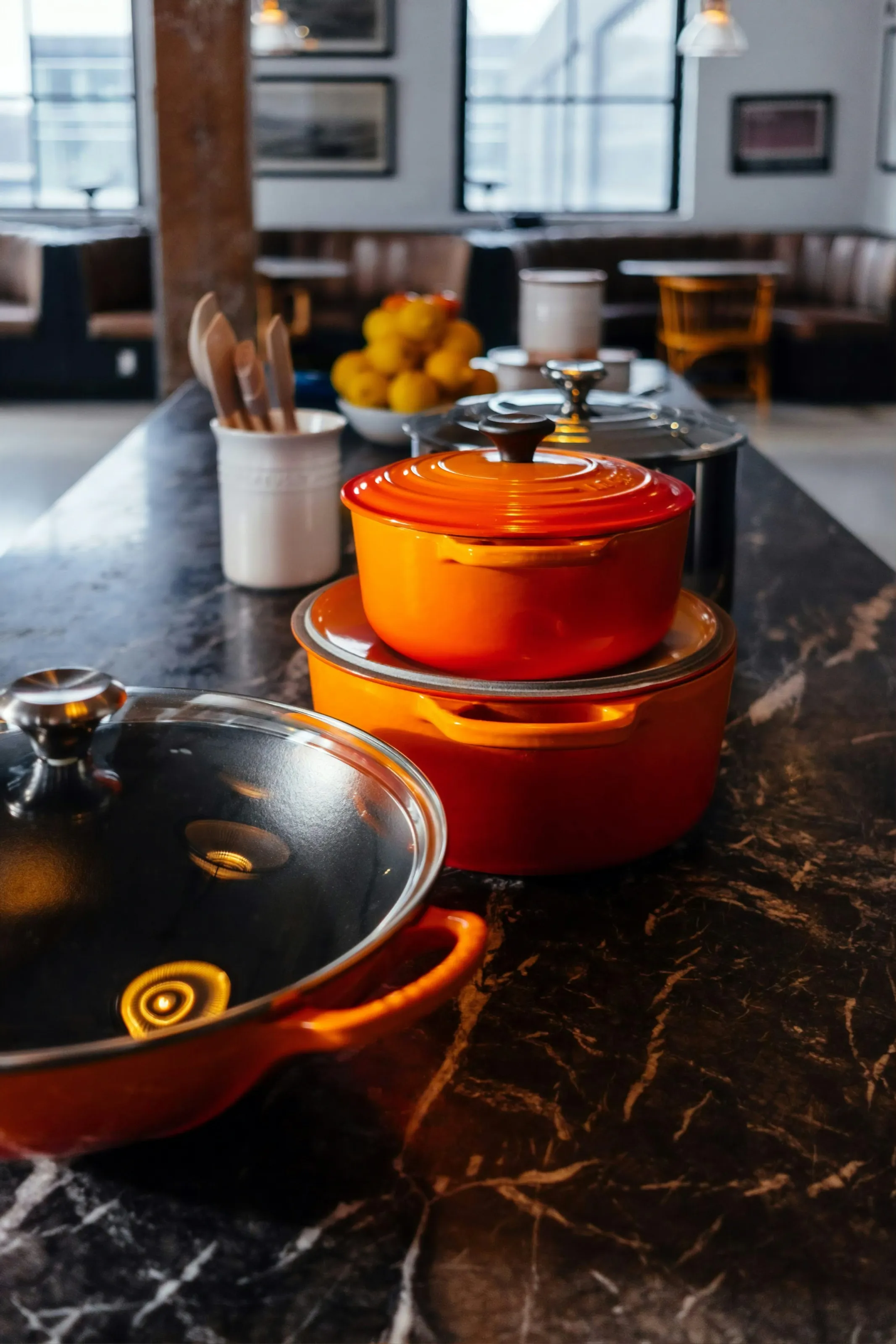 Stock photo of a kitchen with orange cast iron pans. Photo sourced from Unsplash.