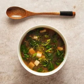 Photo of a bowl of Korean soup with tofu and spinach