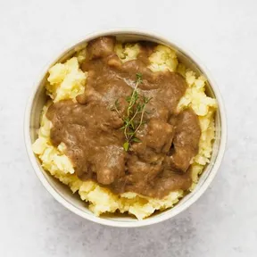 Photo of a bowl of mashed potatoes with miso lentil gravy