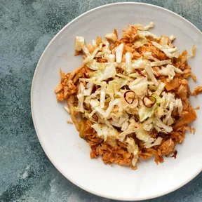 Photo of nasi goreng with green cabbage on a white plate