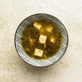 Photo of a bowl of Sichuan tofu soup with pickled mustard leaves