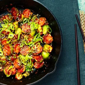 Photo of sticky gochujang  sprouts in a cast iron skillet