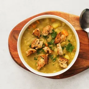 Photo of a bowl of vegan pea soup with croutons