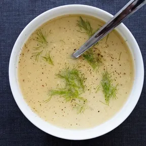 Foto van een kom plantaardige venkelsoep met prei en aardappel