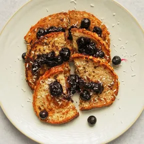 Photo of a plate of French toast with blueberry compote and coconut